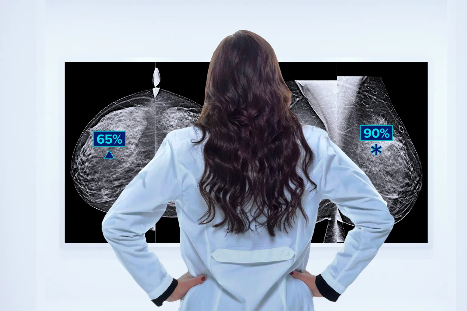 A medical professional looking at a computer screen with breast scan images